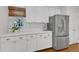 Bright kitchen features white cabinets, stainless steel appliances, and hardwood flooring at 2006 Keokuk Ct, Apex, NC 27523