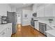 Open kitchen with stainless appliances, white cabinets, and hardwood floors at 2006 Keokuk Ct, Apex, NC 27523