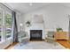 Cozy living room showcasing a fireplace, large window, hardwood floors and comfortable seating at 2006 Keokuk Ct, Apex, NC 27523
