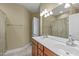 Bathroom featuring double sinks, vanity with cherry wood cabinets, a large mirror, and modern lighting fixtures at 208 Beckingham Loop, Cary, NC 27519