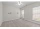 This light and airy bedroom boasts two windows for ample natural light, complemented by neutral walls and carpet at 208 Beckingham Loop, Cary, NC 27519