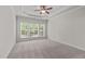 A bedroom featuring a tray ceiling and a large window offering natural light at 208 Beckingham Loop, Cary, NC 27519