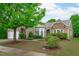 Well-manicured front yard featuring a brick home with a two-car garage and beautiful landscaping around the property at 208 Beckingham Loop, Cary, NC 27519