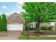 Charming brick home with manicured landscaping, mature tree, and a two-car garage at 208 Beckingham Loop, Cary, NC 27519