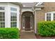 Inviting front entryway featuring a stylish door with sidelights and manicured shrubbery at 208 Beckingham Loop, Cary, NC 27519