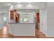 Open kitchen layout with granite countertops, wood cabinets, and access to adjacent rooms at 208 Beckingham Loop, Cary, NC 27519