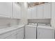 Laundry room with front-loading washer and dryer and upper cabinets at 208 Beckingham Loop, Cary, NC 27519
