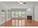 Sunlit living room with hardwood floors, fireplace, and large windows overlooking the backyard at 208 Beckingham Loop, Cary, NC 27519