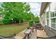 Charming patio with cozy wicker furniture and lush landscaping offers a serene outdoor living space for relaxation and entertainment at 208 Beckingham Loop, Cary, NC 27519