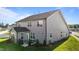 A home's rear exterior featuring a patio, grill, lush lawn, and manicured landscaping at 2096 Dowell Ct, Burlington, NC 27215