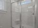 Glass shower with a built-in bench seat and light-colored marble and mosaic tilework at 2096 Dowell Ct, Burlington, NC 27215