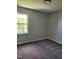 Neutral bedroom featuring carpeted floor and window with tree views at 2121 Lime St, Durham, NC 27704
