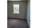 Carpeted bedroom with a window offering a view of the neighborhood at 2121 Lime St, Durham, NC 27704