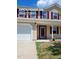 Inviting two-story home featuring a covered porch, maroon shutters, and a well-maintained lawn at 2121 Lime St, Durham, NC 27704
