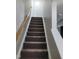 Carpeted staircase with wooden handrail leading to the upper level at 2121 Lime St, Durham, NC 27704