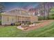 A cozy backyard with a patio, outdoor seating, screened porch, and lush landscaping at 216 Colonial Ridge Dr, Pittsboro, NC 27312
