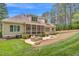 A cozy backyard with a patio, outdoor seating, screened porch, and lush landscaping at 216 Colonial Ridge Dr, Pittsboro, NC 27312