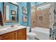 Well-lit bathroom with tub-shower combo, decorative tile, and a modern vanity with framed mirror at 216 Colonial Ridge Dr, Pittsboro, NC 27312