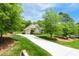 Long driveway leading to a well-maintained home with lush landscaping and a three-car garage at 216 Colonial Ridge Dr, Pittsboro, NC 27312