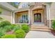 Charming home entrance with a covered porch, stone accents, and manicured landscaping at 216 Colonial Ridge Dr, Pittsboro, NC 27312