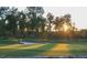 Golf course with bunker, flag, and trees with sunset in background at 216 Colonial Ridge Dr, Pittsboro, NC 27312