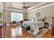 Spacious main bedroom with a tray ceiling, wood floors, a ceiling fan, and lots of natural light at 216 Colonial Ridge Dr, Pittsboro, NC 27312