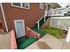 Back entrance with brick exterior and painted green steps at 2315 Oxford Rd, Henderson, NC 27536