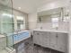 Bright bathroom featuring a dual sink vanity, a glass enclosed shower, and a modern soaking tub with jets at 2315 Oxford Rd, Henderson, NC 27536