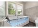 Modern bathtub featuring a glass partition, jets, and a window offering plenty of natural light at 2315 Oxford Rd, Henderson, NC 27536