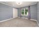 Bedroom with a large window and light blue walls, featuring carpet flooring, white trim, and a spacious closet at 2315 Oxford Rd, Henderson, NC 27536