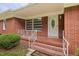 Inviting front porch with brick steps, decorative railing, and a 'Home Sweet Home' welcome mat at 2315 Oxford Rd, Henderson, NC 27536