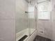 Clean and modern glass-enclosed shower with a tub, featuring a window and tiled walls at 2315 Oxford Rd, Henderson, NC 27536