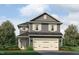 Charming two-story home with gray siding, white trim, and a two-car garage nestled among lush landscaping at 243 New Twin Br Ct, Smithfield, NC 27577