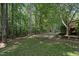 The backyard features a large grassy lawn, mature trees, wood fencing and a playset at 2709 Penfold Ln, Wake Forest, NC 27587