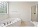 Bathroom boasts a soaking tub, glass-enclosed shower, and neutral tiling at 2709 Penfold Ln, Wake Forest, NC 27587