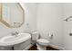 A well-lit powder room features a pedestal sink and hardwood flooring at 2709 Penfold Ln, Wake Forest, NC 27587