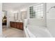 A well-lit bathroom features a soaking tub with tile surround and window providing natural light at 2709 Penfold Ln, Wake Forest, NC 27587