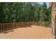Large wooden deck with railing overlooking a lush, green backyard with mature trees at 2709 Penfold Ln, Wake Forest, NC 27587