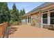 Spacious wooden deck with stone feature on home's exterior, and wooded back yard at 2709 Penfold Ln, Wake Forest, NC 27587