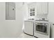 Laundry room featuring modern, white washer and dryer units and overhead storage at 2709 Penfold Ln, Wake Forest, NC 27587