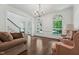 Open-concept living area with hardwood floors, large windows, and elegant chandelier at 2709 Penfold Ln, Wake Forest, NC 27587