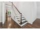 Elegant staircase with dark wood treads and white risers, leading to the upper level at 2709 Penfold Ln, Wake Forest, NC 27587