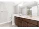 Bathroom featuring a double vanity with framed mirror, and a tiled shower with glass door in background at 2727 Masonboro Ferry Dr, Apex, NC 27502