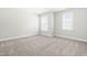 Large bedroom with neutral carpeting and bright natural light from the multiple windows at 2727 Masonboro Ferry Dr, Apex, NC 27502