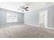 Spacious bedroom with light blue walls and neutral carpeting, lit by a ceiling fan and bright natural light at 2727 Masonboro Ferry Dr, Apex, NC 27502