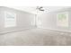 Spacious bedroom with neutral carpeting, ceiling fan, and bright natural light from the multiple windows at 2727 Masonboro Ferry Dr, Apex, NC 27502