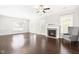 Bright living room with fireplace, hardwood floors, white trim, and chair near the window at 2727 Masonboro Ferry Dr, Apex, NC 27502