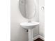 Powder room with pedestal sink, round mirror and white walls at 2727 Masonboro Ferry Dr, Apex, NC 27502