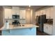 Modern kitchen featuring stainless steel appliances, white cabinets, and a center island at 3112 Star Gazing Ln, Durham, NC 27703
