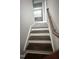 A staircase with wood treads, white risers, and a wooden handrail leads to the upper level at 3112 Star Gazing Ln, Durham, NC 27703